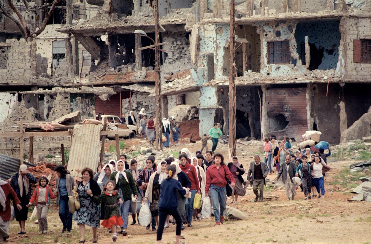 نساء فلسطينيات يغادرن مخيم برج البراجنة للاجئين في ضاحية بيروت الجنوبية عام 1987 بحثاً عن الطعام في السوق القريبة (ا ف ب)