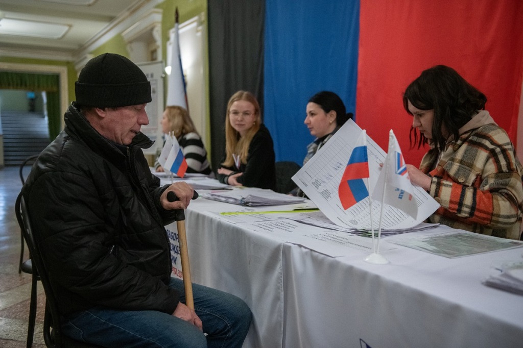 رجل يسجل نفسه للتصويت في الانتخابات الرئاسية الروسية بمركز اقتراع في دونيتسك (أ ف ب).jpg