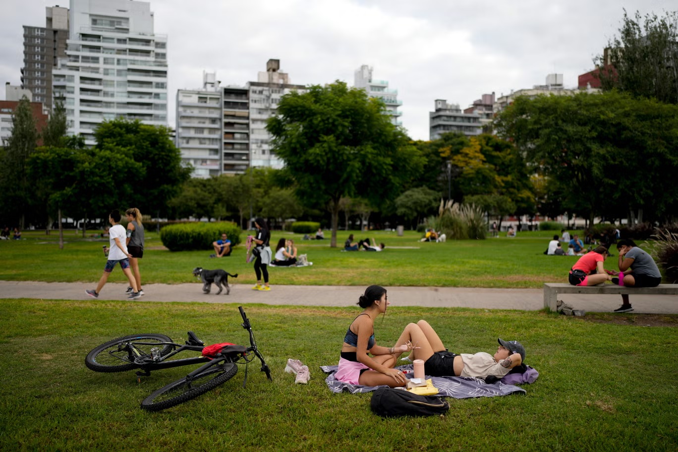 أشخاص يتسكعون في حديقة في روزاريو، الأرجنتين، الإثنين الثامن من أبريل 2024. مسقط رأس ليونيل ميسي (أ ب)