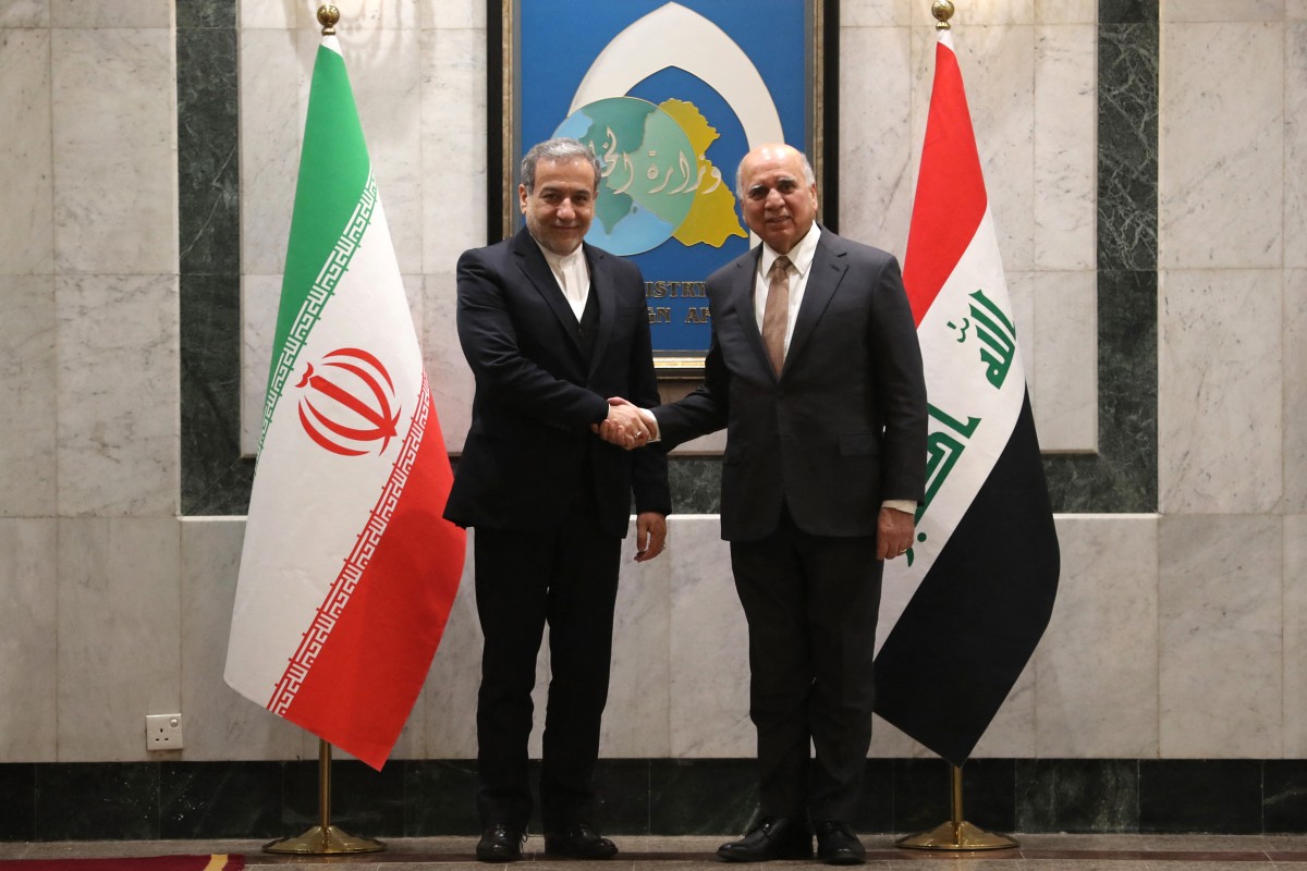 وزير الخارجية العراقي فؤاد حسين (يمين) يرحب بنظيره الإيراني عباس عراقجي قبل اجتماعهما في بغداد.jpg
