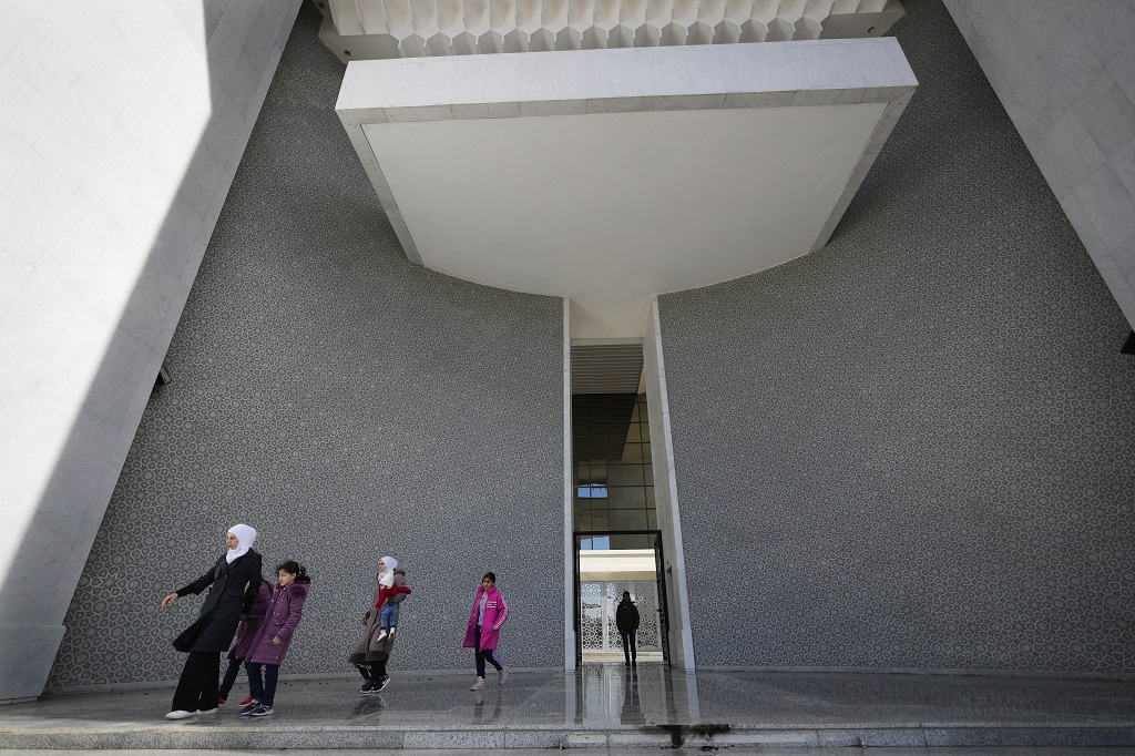 مجموعة من السوريين يغادرون القصر الرئاسي في دمشق، 8 ديسمبر 2024 (أ ب).jpg