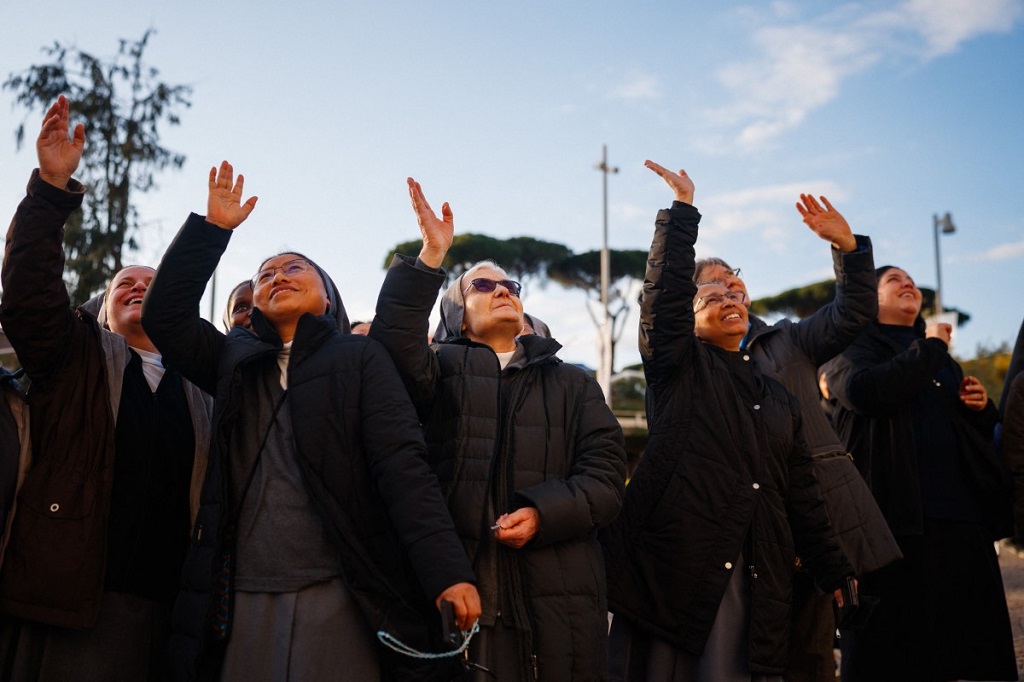 الراهبات يلوحن نحو مستشفى جيميلي الجامعي حيث يرقد البابا فرانسيس، 2 مارس 2025 (أ ف ب).jpg