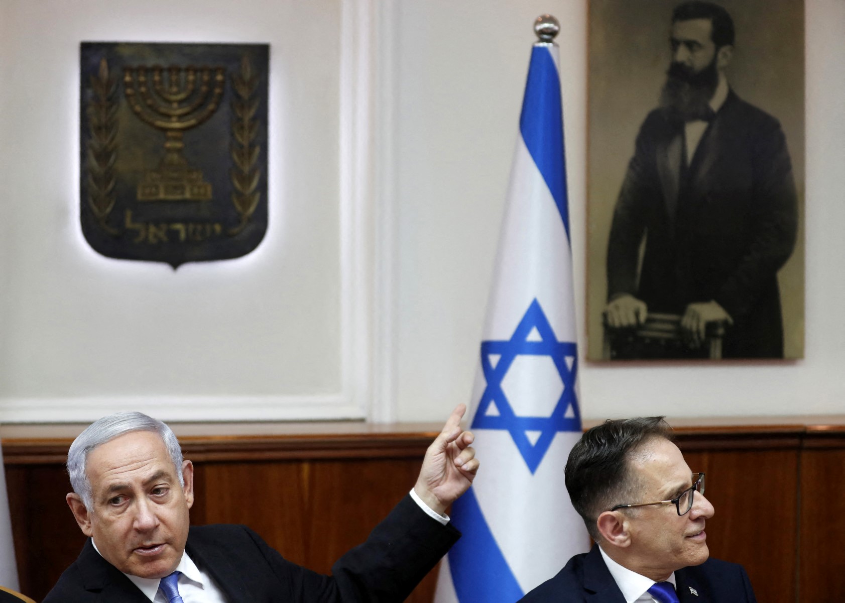 نتنياهو يشير إلى صورة لتيودور هرتزل مؤسس الصهيونية أثناء حضوره اجتماعا لمجلس الوزراء عام 2019 (أ ف ب).jpg