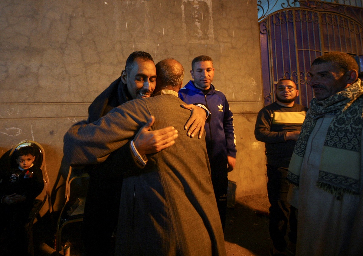 أحمد عزيز المصري يتلقى عناقًا بينما يحيط به أشخاص جاؤوا لتهنئته على عودته إلى قريته أبو شنب.JPG