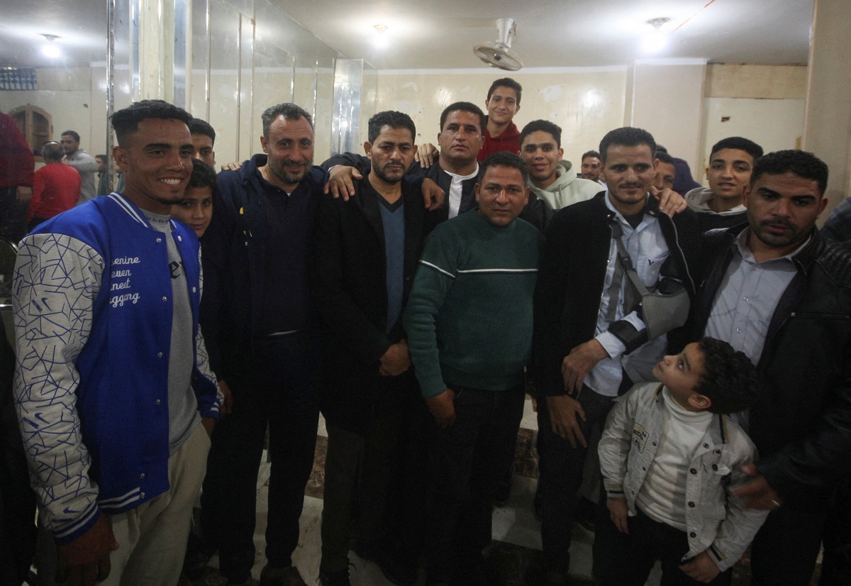 ماجد معوض وشقيقه عماد معوض محاطان بأشخاص جاؤوا لتهنئتهما على عودتهما إلى قريتهما أبو شنب في مدينة الفيوم بمصر، 6 مارس 2025..JPG