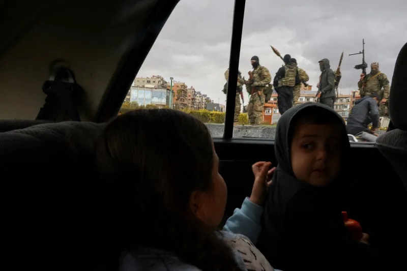 لواء من "هيئة تحرير الشام" يحتفل بإطاحة الرئيس السوري السابق بشار الأسد، في دمشق، ديسمبر 2024 (رويترز)