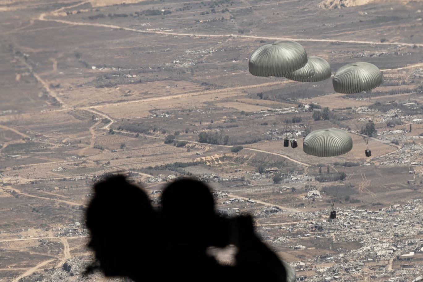 صناديق المساعدات الغذائية ووزنها طن واحد في أجواء غزة بعدما ألقاها الجيش الأردني (بيل ترو)