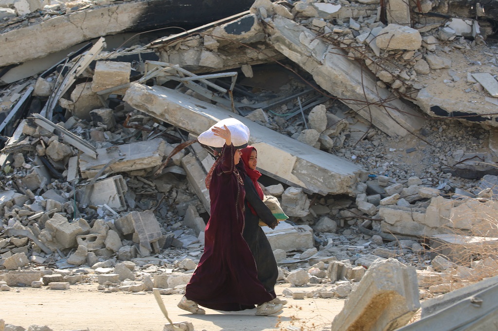 تحمل فلسطينيتان أكياس مساعدات إنسانية (أ ف ب).jpg