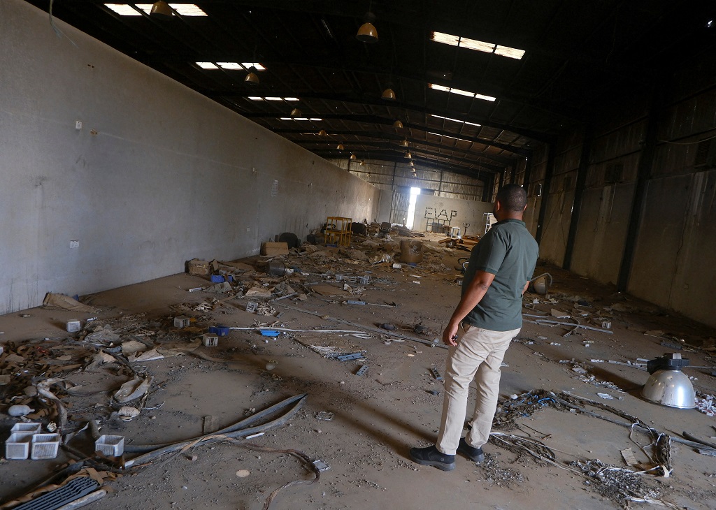 صاحب مصنع ينظر إلى أنقاض مصنعه في الخرطوم بحري، السودان، 15 أكتوبر 2025 (رويترز).JPG