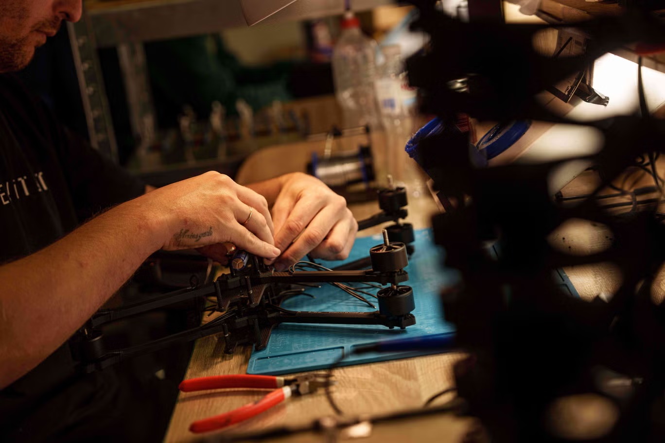 مهندس يعمل على تجميع مسيرة تعمل بالرؤية المباشرة (أ ب)