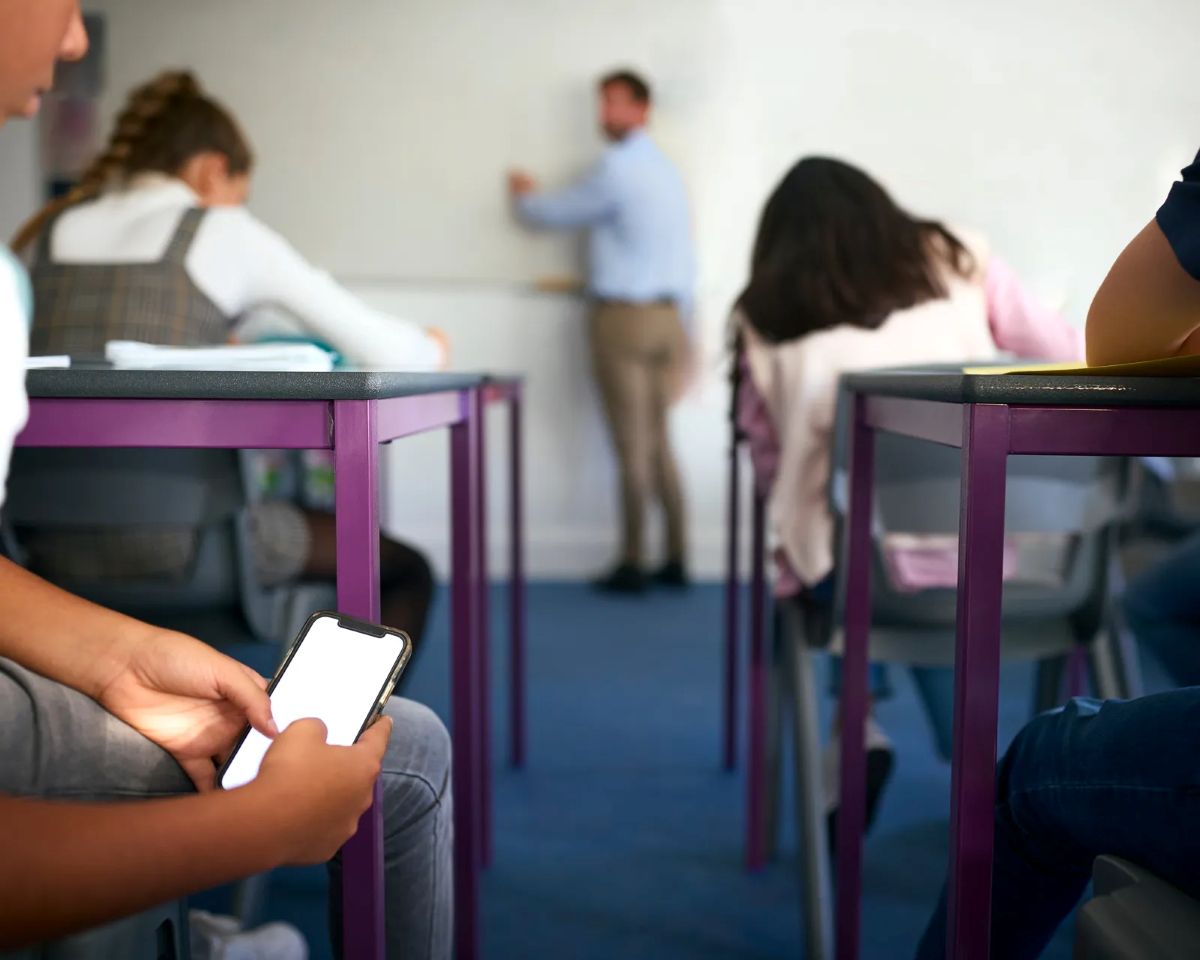 Close-up-of-two-male-Pupils-Looking-At-Mobile-Phone-During-Lesson.jpg