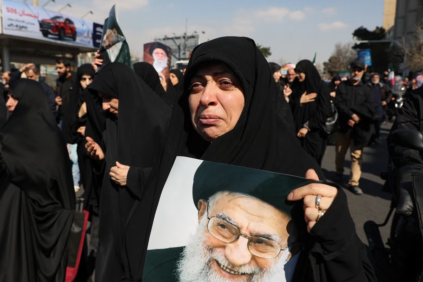 امرأة تحمل صورة المرشد الأعلى الإيراني الراحل آية الله علي خامنئي خلال تجمع في طهران يوم الجمعة (وكالة أنباء غرب آسيا)
