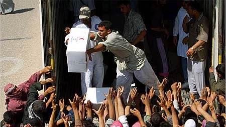 توزيع طرود المساعدات من قبل الهلال الأحمر في مدينة صفوان جنوب العراق عام 2003 (رويترز).jpeg