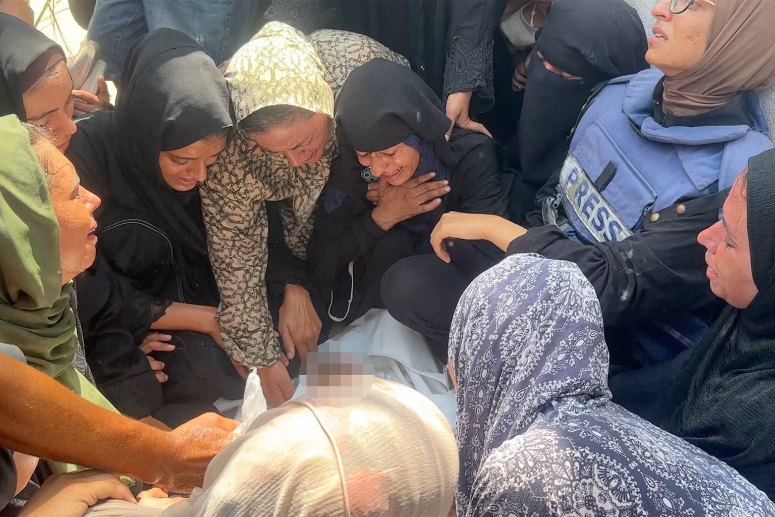 مشيّعون يعبرون عن حزنهم، بمن فيهم براء على اليسار، حول جثمان مريم (لقطة شاشة)