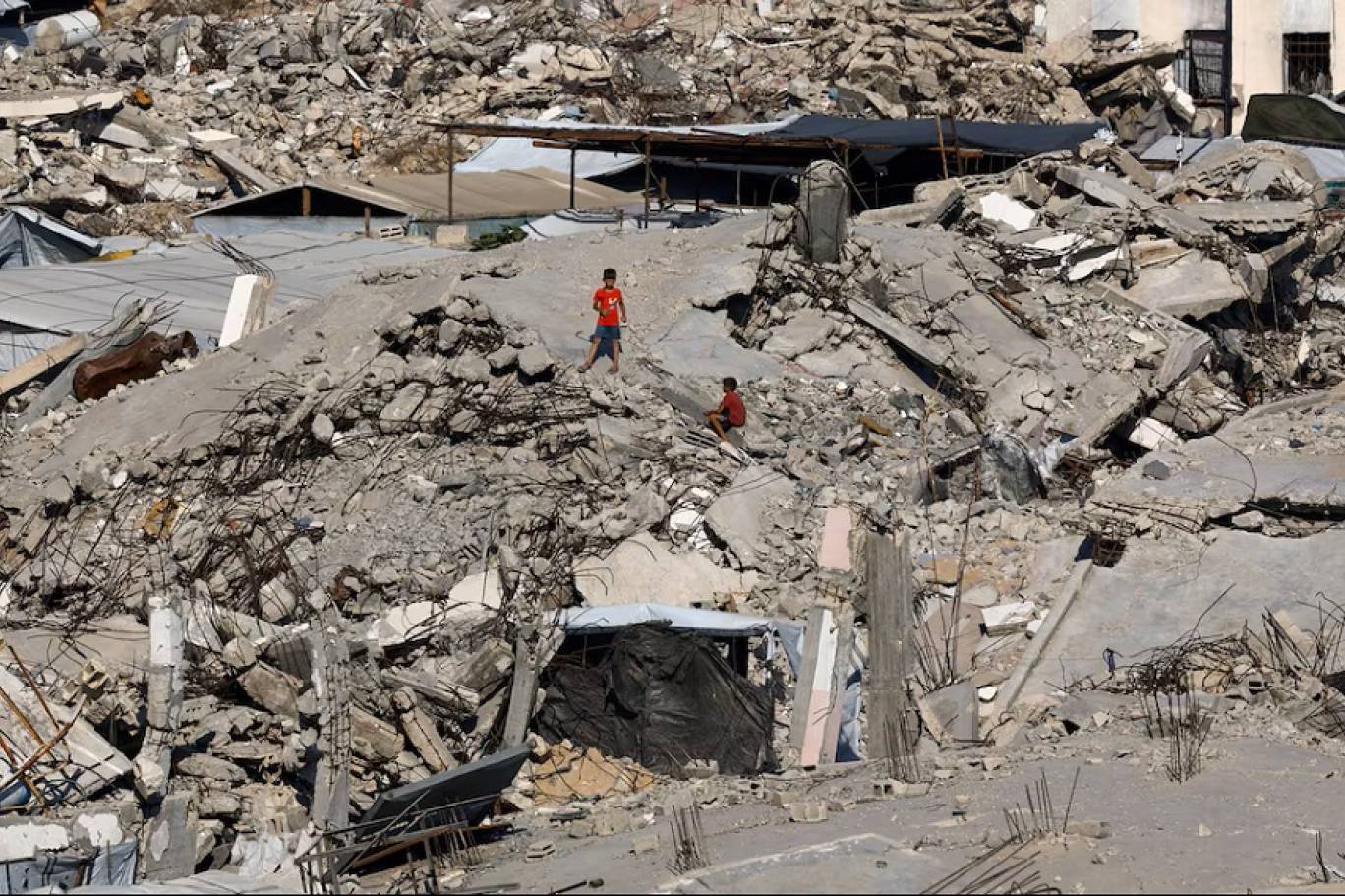 طفلان فلسطينيان وسط أنقاض المباني التي دمرت خلال الحرب في مخيم جباليا للاجئين شمال قطاع غزة (رويترز)