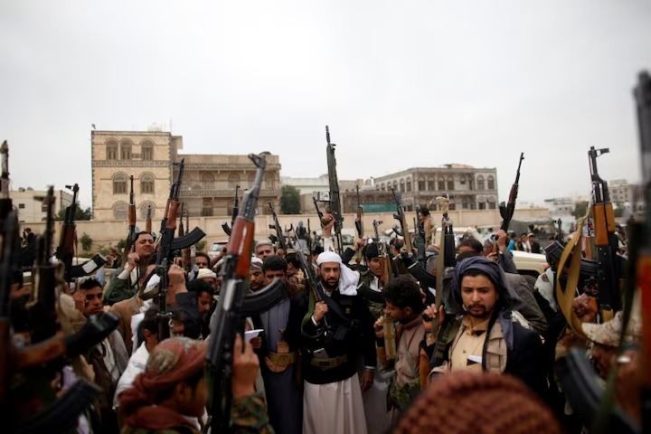 مقاتلون حوثيون يرتدون الزي الشعبي ويلوحون بأسلحتهم (رويترز).